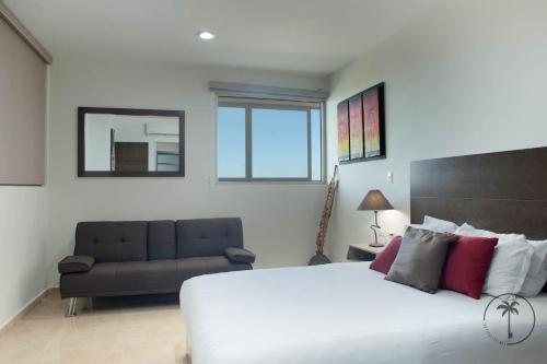 a bedroom with a large bed and a couch at Spacious Apartment with Private Balcony & Ocean View - Brujas in Mazatlán