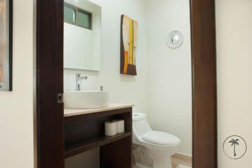 y baño con lavabo y aseo. en Spacious Apartment with Private Balcony & Ocean View - Brujas en Mazatlán