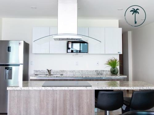 a kitchen with white cabinets and a counter top at Moderno condominio con vista al mar! in Mazatlán