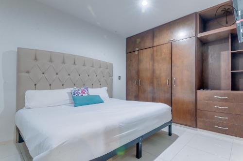 a bedroom with a large bed and wooden cabinets at ALFA - Dpto 2 hab en zona céntrica y cerca de la playa in Mazatlán