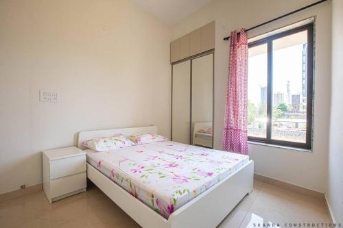a white bedroom with a bed and a window at Stunning Haven 2BHK Condo - Muttukadu ECR in Chennai