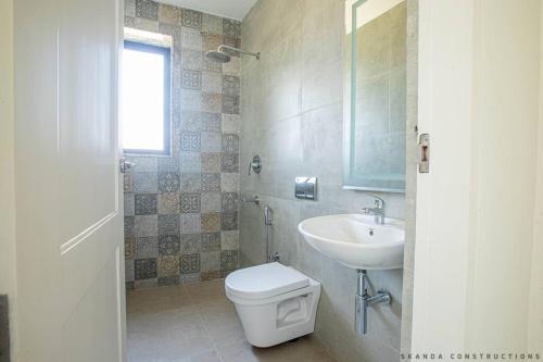 a bathroom with a toilet and a sink at Stunning Haven 2BHK Condo - Muttukadu ECR in Chennai