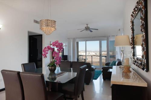 a dining room and living room with a table and chairs at Spacious Apartment with Pool Facing the Ocean in Mazatlán - Marina in Mazatlán