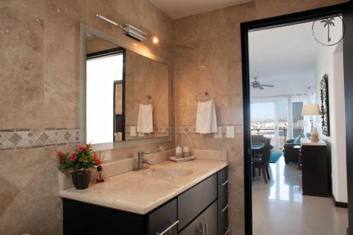 baño con lavabo y espejo grande en Spacious Apartment with Pool Facing the Ocean in Mazatlán - Marina, en Mazatlán