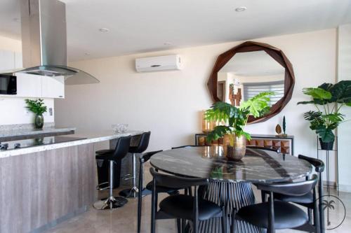 a dining room with a table and chairs and a mirror at Nuevo Departamento en el Malecón! in Mazatlán