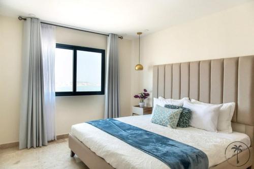 Un dormitorio con una cama grande y una ventana en Nuevo Departamento en el Malecón! en Mazatlán