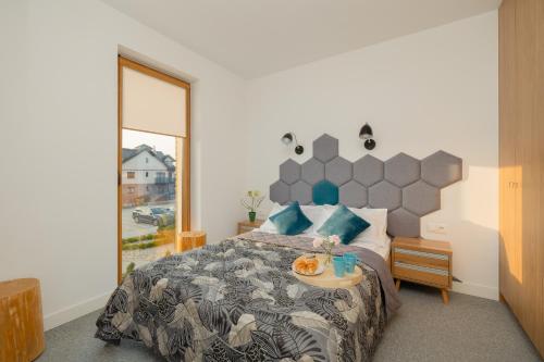 um quarto com uma cama grande e uma janela em Marynarska Modern Apartment with Parking by Renters em Sarbinowo