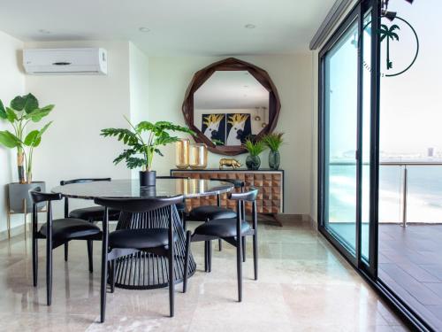 a dining room with a table and chairs and a mirror at Hermosa Vista al Mar, Condominio de Lujo! in Mazatlán