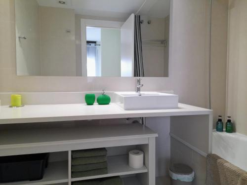 y baño con lavabo blanco y espejo. en Apartamento Lliris Sol en L'Estartit