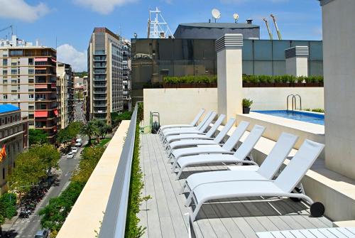 a row of white lounge chairs on top of a building at Holihome Rambla 24 in Alicante