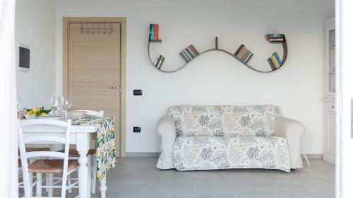 een woonkamer met een bank, een tafel en een spiegel bij Welcomely - La Casa Sul Mare in Cala Liberotto