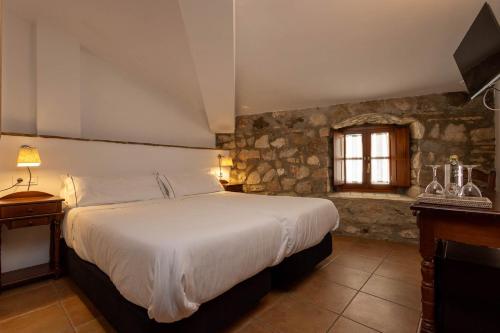 - une chambre avec un grand lit et une fenêtre dans l'établissement Tugasa Hotel La Posada, à Villaluenga del Rosario