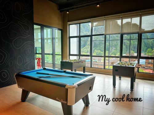 a pool table in the middle of a room with windows at Sunway Onsen Suite Theme Park View Top Floor at Lost World in Tambun