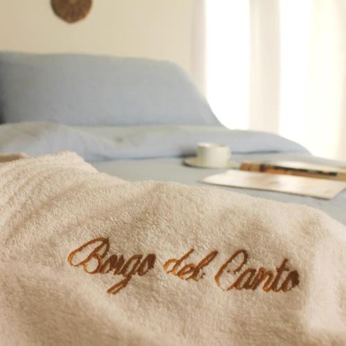 a towel with the words angel all farms on a bed at Agriturismo Borgo del Canto in Borghetto dʼArroscia