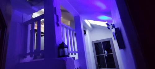 a purple light shines on a hallway of a house at Studio duplex atypique, classé Gîte de France, CLIMATISATION, parking, lit double, calme et cosy, Netflix, wifi, 400m centre, boîte à clés, Gîtes La Tarine in Albertville