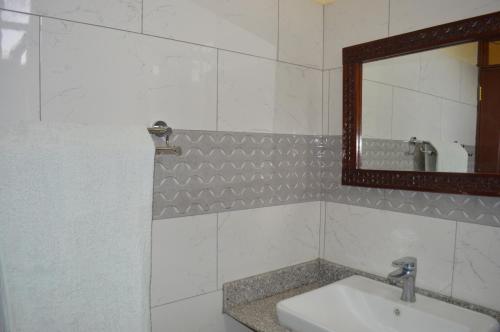 een badkamer met een wastafel en een spiegel bij Holale Hotel in Moyale