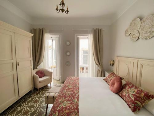 a bedroom with a large bed and a chair at La Gitanilla Alojamiento & Encanto Jerez in Jerez de la Frontera