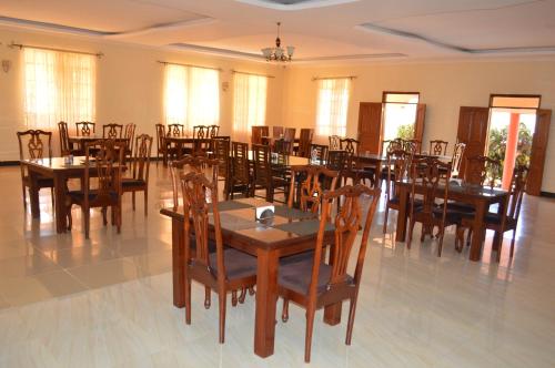 een eetkamer met houten tafels en stoelen bij Holale Hotel in Moyale