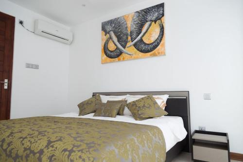 a bedroom with a bed and a painting on the wall at Crown Properties in Colombo