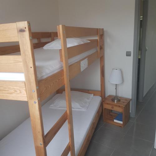 - deux lits superposés dans une chambre avec une lampe dans l'établissement Lacanau Océan- Bel appart- 2 Ch, à Lacanau-Océan