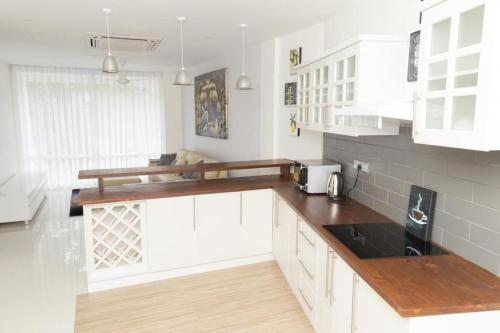 a kitchen with white cabinets and wooden counter tops at Crown Properties in Colombo