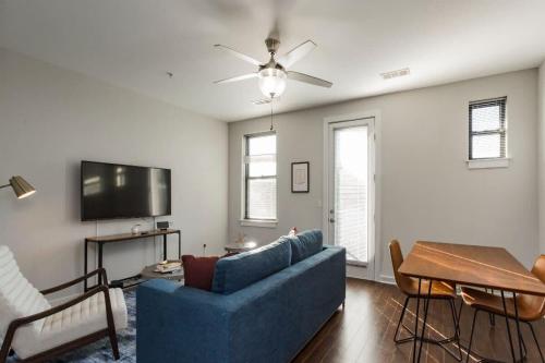 a living room with a blue couch and a tv at CozySuites MusicRow Astonishing Studio with free parking 38 in Nashville