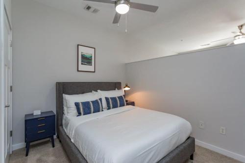 a bedroom with a white bed and a blue nightstand at CozySuites MusicRow Astonishing Studio with free parking 38 in Nashville