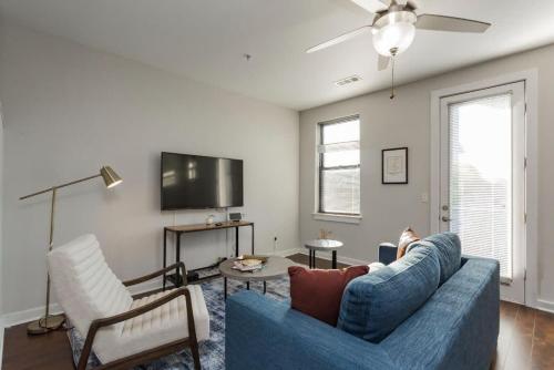 a living room with a blue couch and a tv at CozySuites MusicRow Astonishing Studio with free parking 38 in Nashville