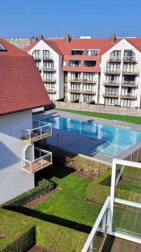 uma vista superior de uma piscina com edifícios em Charmante studio Nicky em Middelkerke