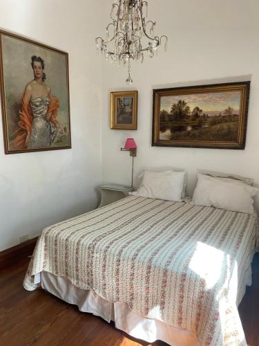 sypialnia z łóżkiem z obrazem i żyrandolem w obiekcie Departamento en Casco Historico w mieście San Isidro