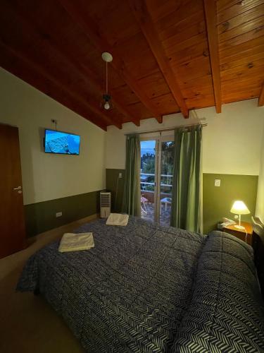 a bedroom with a bed with a tv on the wall at Don Hugo in Villa Giardino