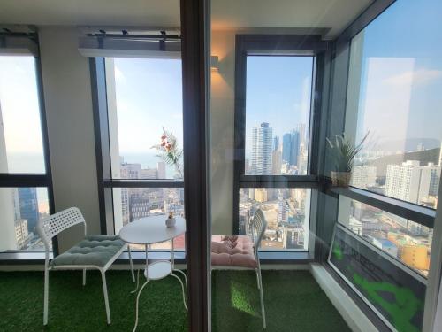 a room with a table and chairs and windows at ELBON the stay Haeundae beach ocean view in Busan