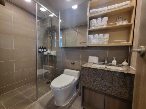 a bathroom with a toilet and a glass shower at ELBON the stay Haeundae beach in Busan