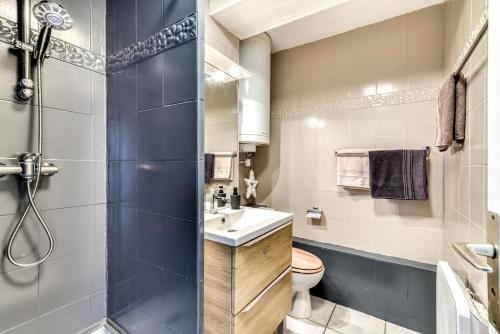 ein Bad mit einer Dusche, einem WC und einem Waschbecken in der Unterkunft T2 Miami Beach in Narbonne-Plage