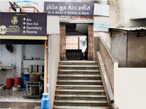 a staircase leading up to a building with a sign at OYO Hotel Moon in Rajkot