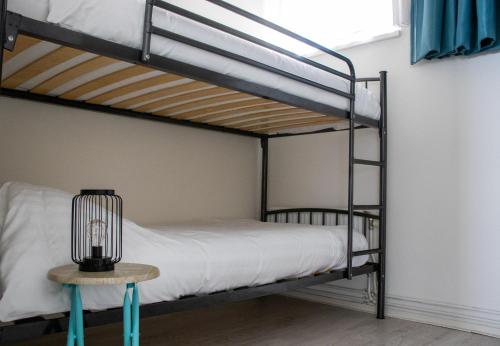 a bedroom with two bunk beds and a table with a lamp at Zeezand in Egmond aan Zee