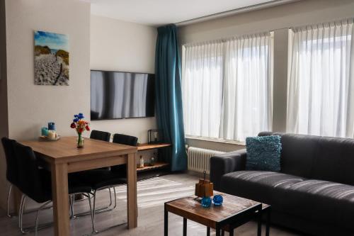 a living room with a couch and a table at Zeezand in Egmond aan Zee