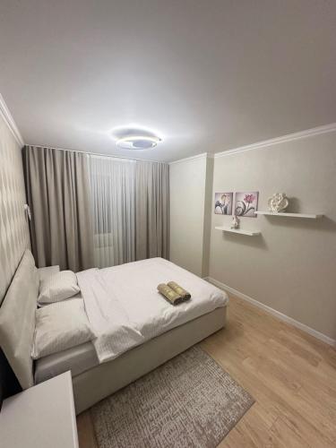 a white bedroom with a bed and a rug at Lux Apartmen Zona Circ in Chişinău