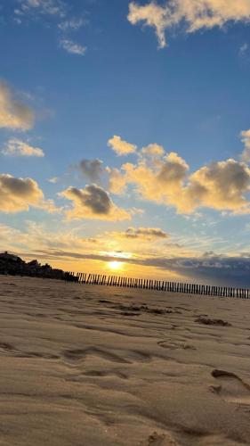 a view of the beach at sunset with a pier at les Calimottes in Sangatte