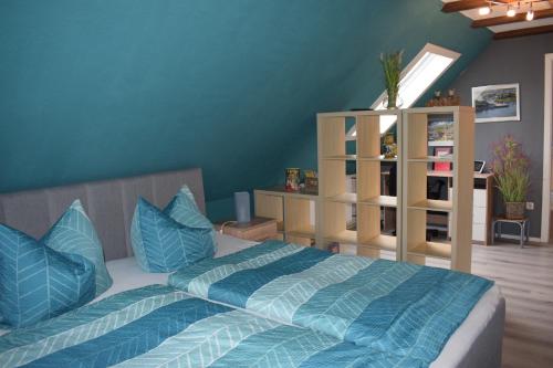 ein Schlafzimmer mit einem Bett mit blauen Kissen in der Unterkunft Marktstübchen an der schönen Loreley in Bornich