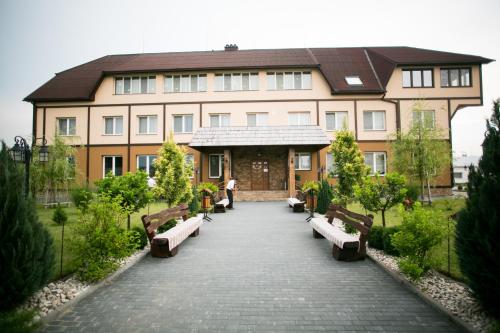 a large building with benches in front of it at Tulipan Hotel Aquapark in Vyshkove
