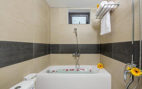 a bathroom with a tub with a shower and a toilet at SILANA HOTEL & APARTMENT in Da Nang