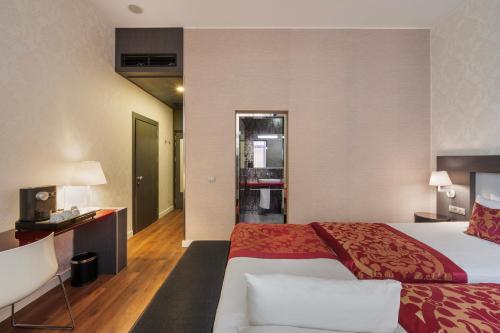 a hotel room with a large bed and a desk at Eurostars Palazzo Zichy in Budapest