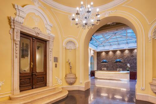 a large room with a chandelier and a lobby at Eurostars Palazzo Zichy in Budapest