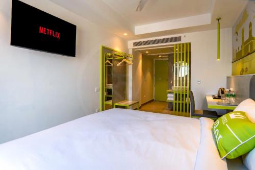 a hotel room with a bed and a bathroom at Le Roi Dehradun at Dehradun Railway Station in Dehradun