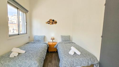 2 camas individuais num quarto com uma janela em The Lemon Tree Hostel em Lárnaca