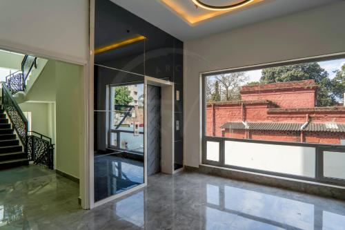 an open glass door in a house with a window at Le Roi Dehradun at Dehradun Railway Station in Dehradun