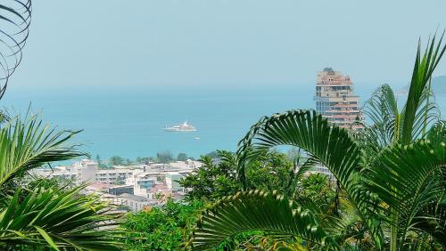 a cruise ship in the ocean with buildings and palm trees at Baiyok Villa seaview and edge pool in Patong Beach