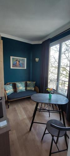 un salon avec une table et un canapé dans l'établissement Studio proche de la defense, à Nanterre
