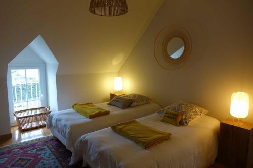 two beds in a room with two lamps and a mirror at La Maison de Saint-Dyé in Saint-Dyé-sur-Loire